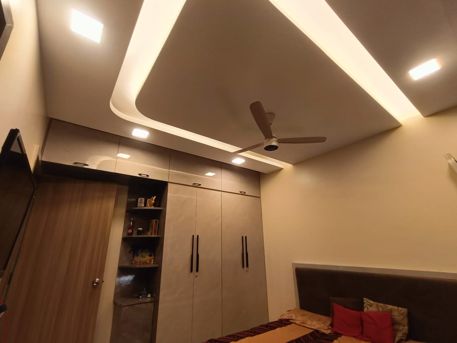 Bedroom wardrobes with cove-lit false ceiling by Artmarque, Pune