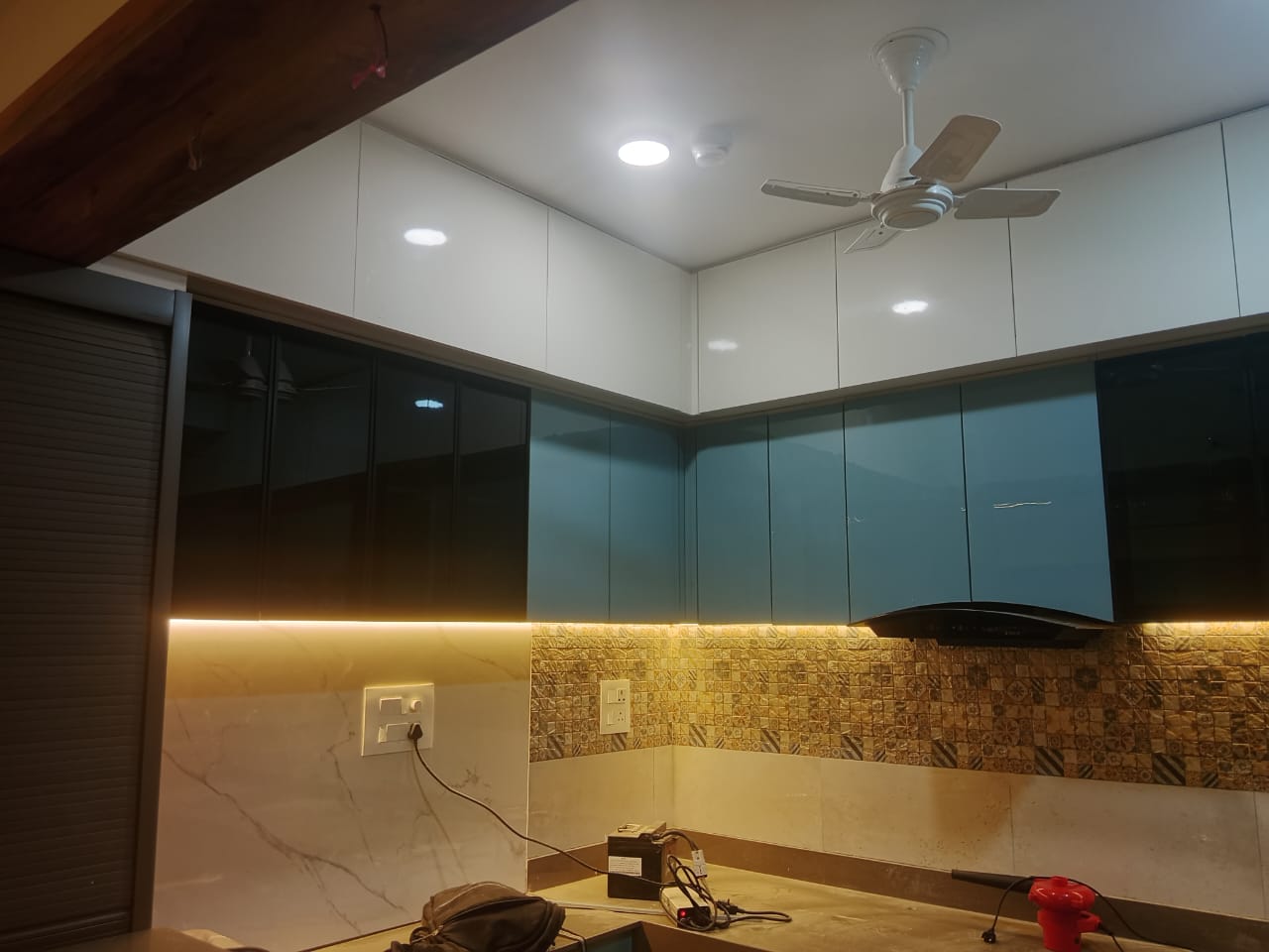 Modular kitchen with teal acrylic cabinets designed by Artmarque, Pune